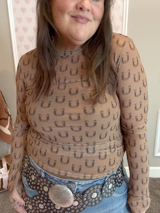 Model wearing the Black Horseshoe Mesh Top with thumbhole sleeves and a fitted silhouette, styled with denim jeans for a trendy western-inspired fall look.
