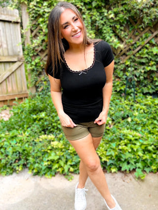 Woman wearing the Lace Trim Ribbed Tee, styled casually with jeans for a chic, feminine look.