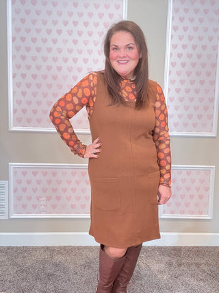 Chocolate brown ribbed jumper dress with soft, stretchy fabric — perfect for layering over mesh tops or sweaters for cozy fall style.