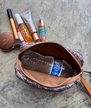 Makeup bag with cosmetic products on a textured surface