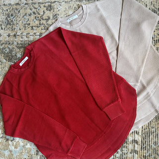 Crimson red luxury corded sweatshirt with oversized fit, rounded scooped hemline, and ribbed crew neckline and cuffs — soft 100% cotton with vintage-washed finish.