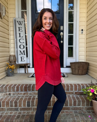 Crimson red luxury corded sweatshirt with oversized fit, rounded scooped hemline, and ribbed crew neckline and cuffs — soft 100% cotton with vintage-washed finish.