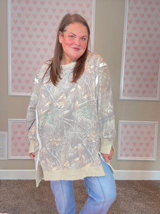 Soft camo print crew pullover with exposed seams, ribbed trim, and split cuff hem — oversized, slouchy fit with cozy sweatshirt interior.