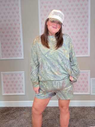 Soft camo lounge set with long sleeve top featuring pocket detail and matching elastic waistband shorts — cozy, stretchy, and perfect for everyday comfort.