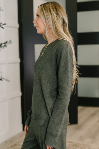 Woman wearing a green sweater in an indoor setting