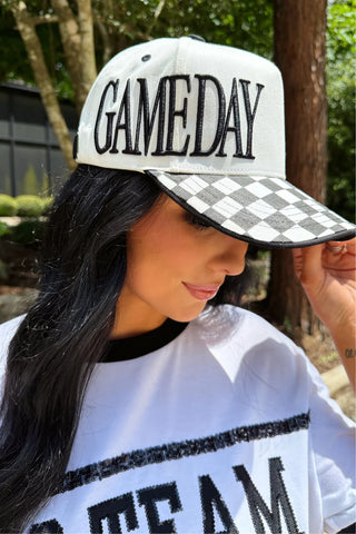 Black and white checkered game day hat with embroidered lettering and adjustable back closure. 