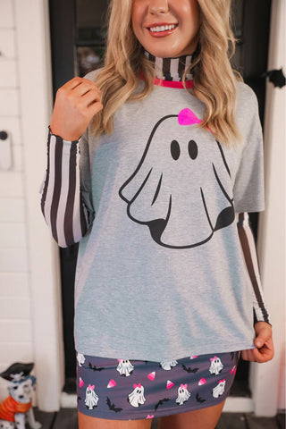 Person wearing a gray shirt with a ghost design and a matching skirt.