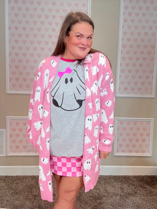 Person wearing a pink outfit with ghost design on a neutral background
