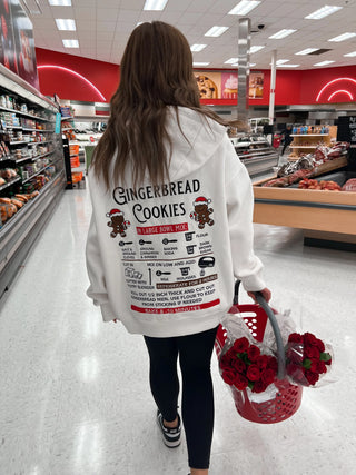 Person wearing a ivory sweatshirt with gingerbread cookie recipe.