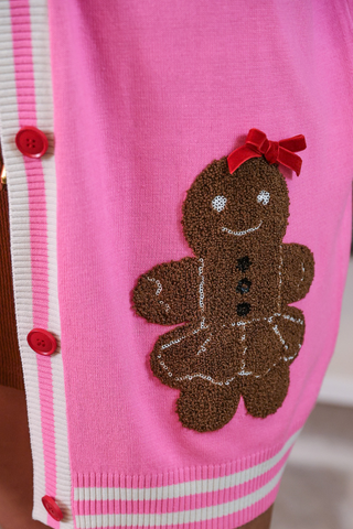 Pink sweater with a gingerbread man design on a blurred background