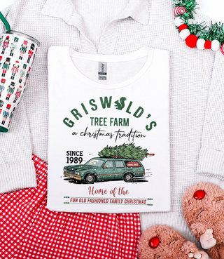 White t-shirt with 'Griswold's Tree Farm' design on a white background with Christmas decor.