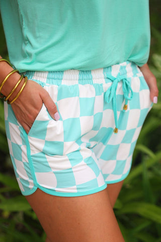 Mint checkered printed mid-rise everyday shorts with a relaxed fit, drawstring tie waist, and side pockets, styled for casual spring and summer wear.