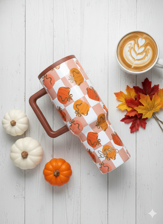 Coffee mug with pumpkin design on a white wooden surface with pumpkins and leaves.