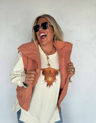 Soft oversized crew pullover with embroidered Highland cow on front, exposed seams, ribbed trim, and split cuff detail — cozy sweatshirt feel with western charm.