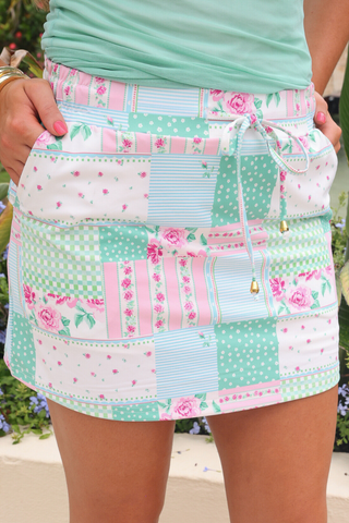 Woman wearing Heirloom Patchwork Skort featuring vintage-inspired patchwork print, elastic drawstring waistband, and built-in shorts, styled with a casual top for a chic comfy mom outfit.