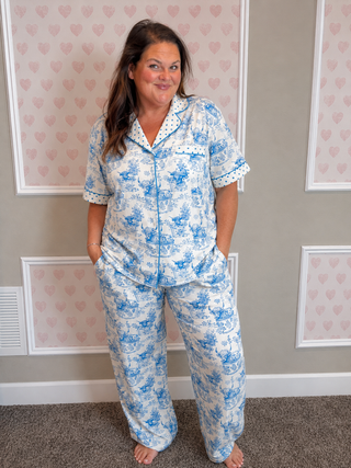Blue and white highland cow print pajama set with embroidered Relax Heifer collar, scalloped trim, button top, and soft lounge pants with pockets. 🐄💕