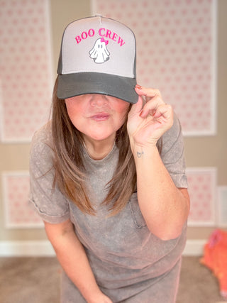 Person wearing a cap with 'BOO CREW' text in a room with pink walls.