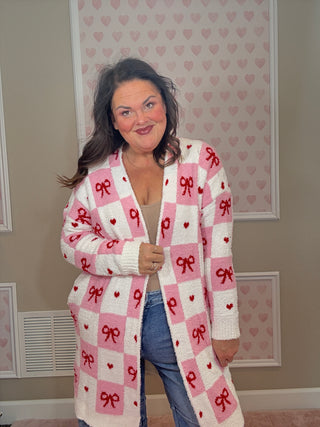 Valentine’s edition cloud cardigan for women featuring ultra-soft cozy fabric with a checkered pattern and bow details, perfect for comfy mom style and chic mom-approved looks.