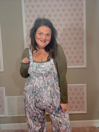 Woman wearing a camo jumpsuit overalls. 
