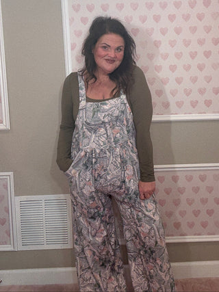 Woman wearing a camo jumpsuit overalls. 