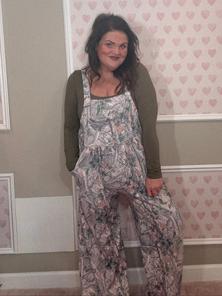 Woman wearing a camo jumpsuit overalls. 