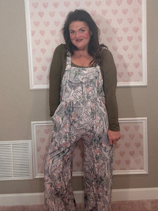 Woman wearing a camo jumpsuit overalls. 