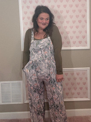 Woman wearing a camo jumpsuit overalls. 