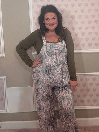 Woman wearing a camo jumpsuit overalls. 