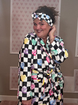 Checkered conversation hearts spa headband featuring a soft plush fabric and Valentine-inspired heart design, perfect for self-care routines and women’s accessories.