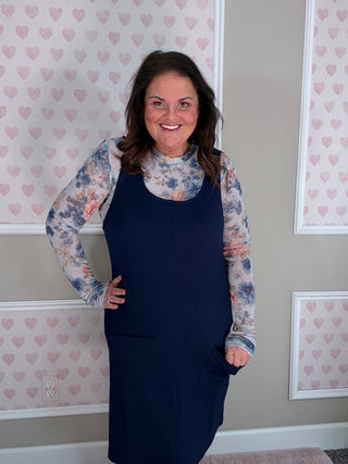 Woman wearing the Rory Ribbed Jumper Dress in navy featuring soft stretchy ribbed fabric and classic scoop neckline.