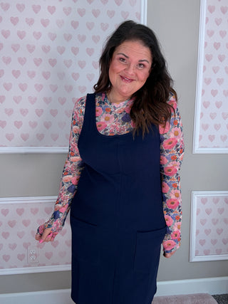 Woman wearing the Rory Ribbed Jumper Dress in navy featuring soft stretchy ribbed fabric and classic scoop neckline.
