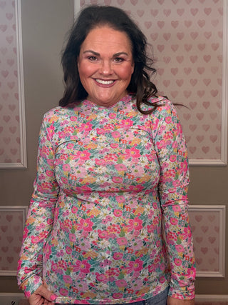 Woman wearing pink floral mesh long sleeve top with sheer stretchy fabric styled with denim for feminine spring outfit.