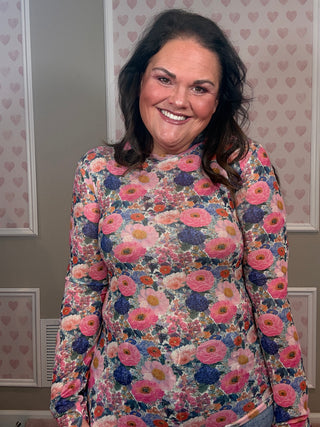 Woman wearing pink French garden floral mesh long sleeve top with sheer stretchy fabric styled with denim for feminine spring outfit.