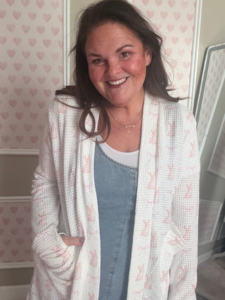 Woman lying on a bed with a patterned wall in the background