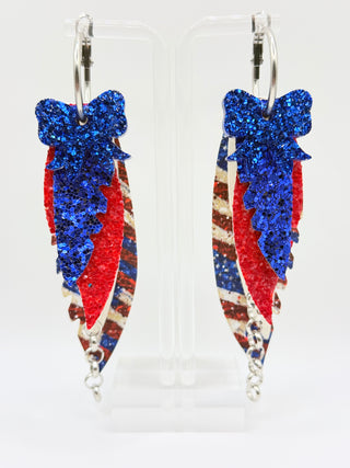 Red white and blue patriotic statement earrings with glitter bow accent, vintage Americana faux leather feather details, silver chain charm, and lightweight boutique design.