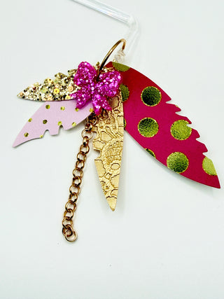Pink and gold statement earrings with glitter bow accent, layered faux leather feather details, metallic polka dots, gold chain charm, and lightweight boutique design.