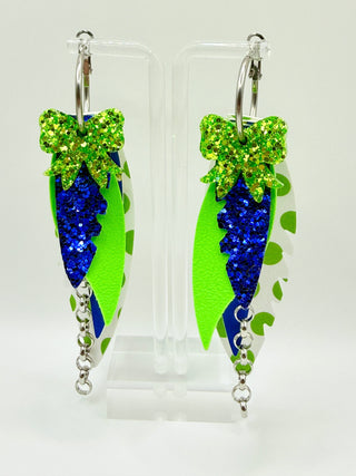 Layered blue and lime green statement earrings with glitter bow accent, polka dot faux leather feathers, silver chain detail, and lightweight boutique design.