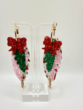 Layered strawberry print statement earrings with red glitter bow, pink sparkle accents, faux leather feather details, and rose gold chain charm.