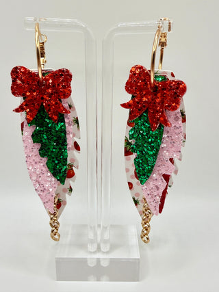Layered strawberry print statement earrings with red glitter bow, pink sparkle accents, faux leather feather details, and rose gold chain charm.