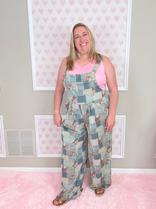 Woman wearing a floral patchwork dress in a room with pink walls and framed pictures.