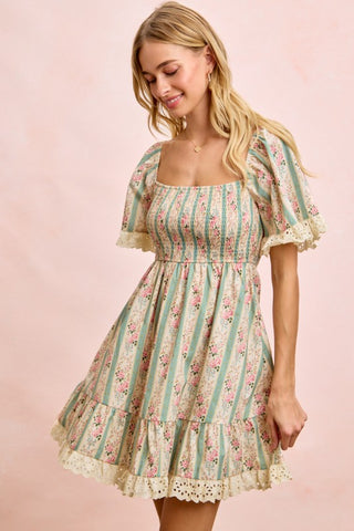 Woman wearing a floral and striped dress on a pink background