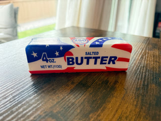 Squishy 4oz salted butter with American flag design on a wooden table