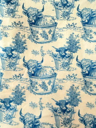 Pattern of blue Highland cows in teacups on a beige background