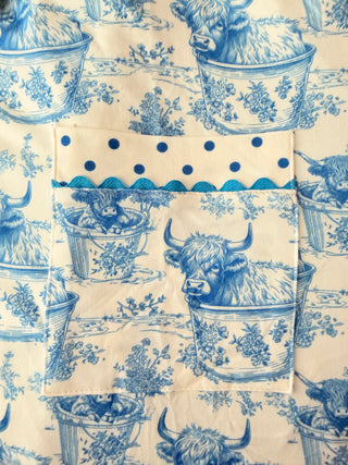 Blue and white patterned fabric with teapots and floral designs on a beige background
