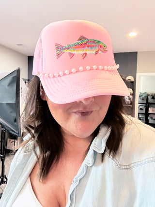 Pink foam trucker hat with colorful rainbow trout graphic and pearl hat chain.