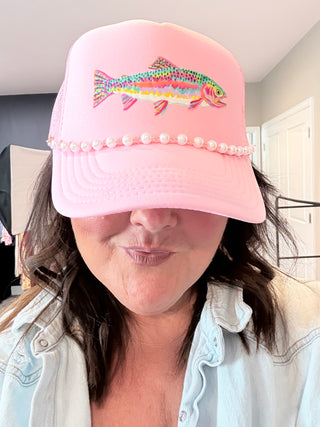 Pink foam trucker hat with colorful rainbow trout graphic and pearl hat chain.