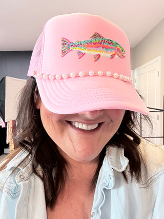 Pink foam trucker hat with colorful rainbow trout graphic and pearl hat chain.