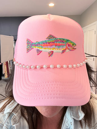 Pink foam trucker hat with colorful rainbow trout graphic and pearl hat chain.
