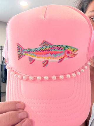 Pink foam trucker hat with colorful rainbow trout graphic and pearl hat chain.