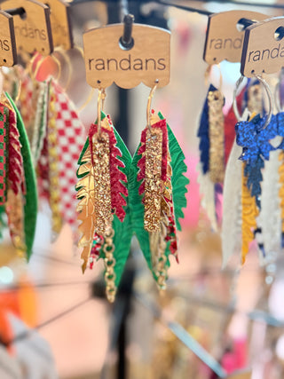 Colorful earrings on display with 'randans' branding.